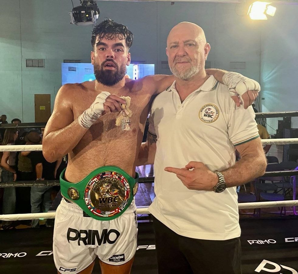 Elijah Estanislao wearing the WBC MuayThai British Cruiserweight Championship belt alongside his coach