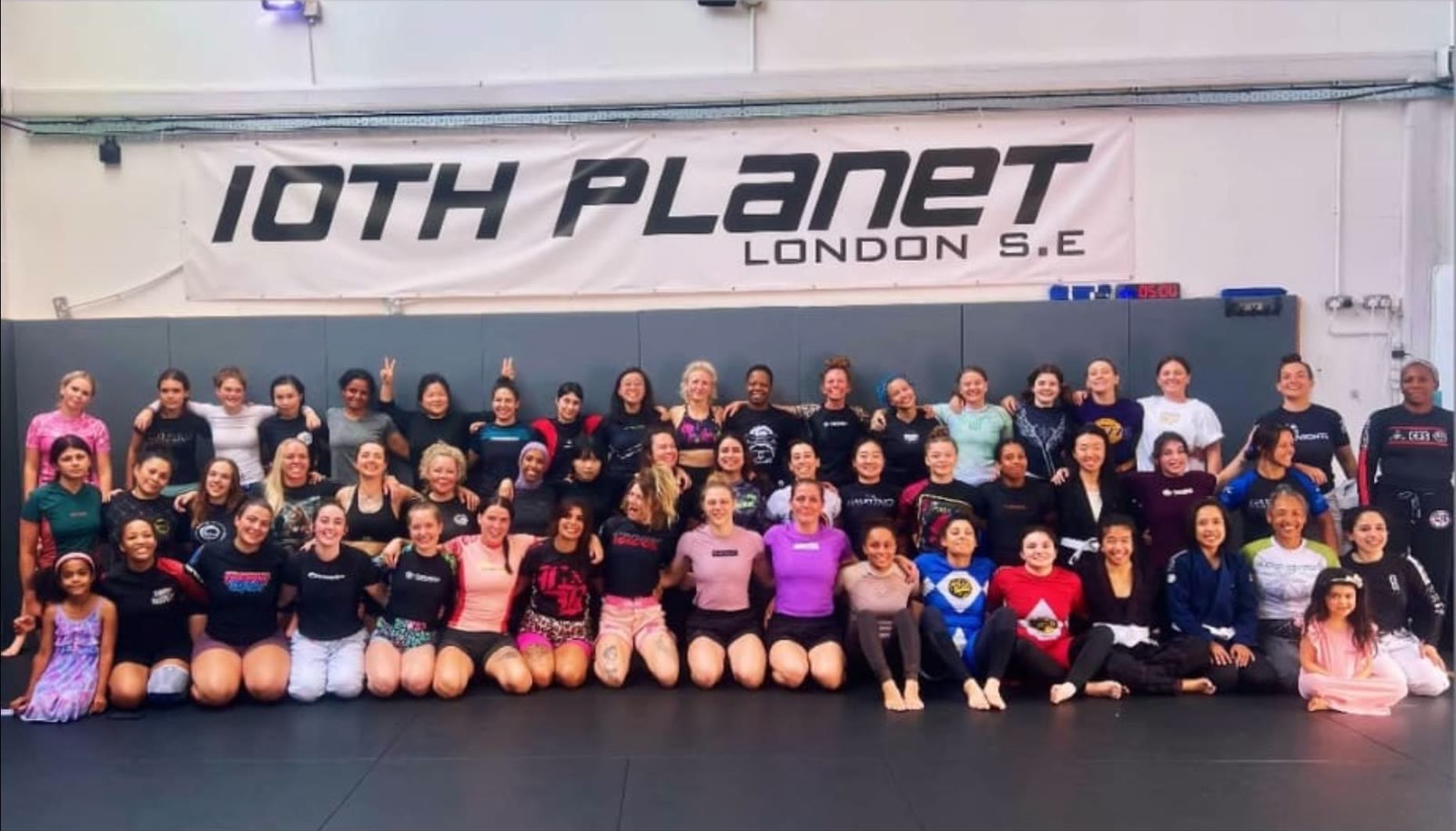 Women grapplers from the Women’s London Open Mat pose together on the mats at 10th Planet London S.E.